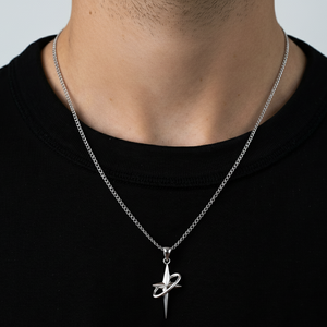 Silver necklace with a unique pendant on a person wearing a black shirt.
